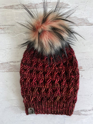Hand dyed Merino wool in deep red tones.  Topped with a HANDMADE snap on faux fur pom-pom in a deep blush center, to light blush, with long, black whisps. Light weight beanie.